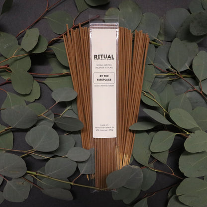 Pack of incense sticks with a label on a dark background with green leaves