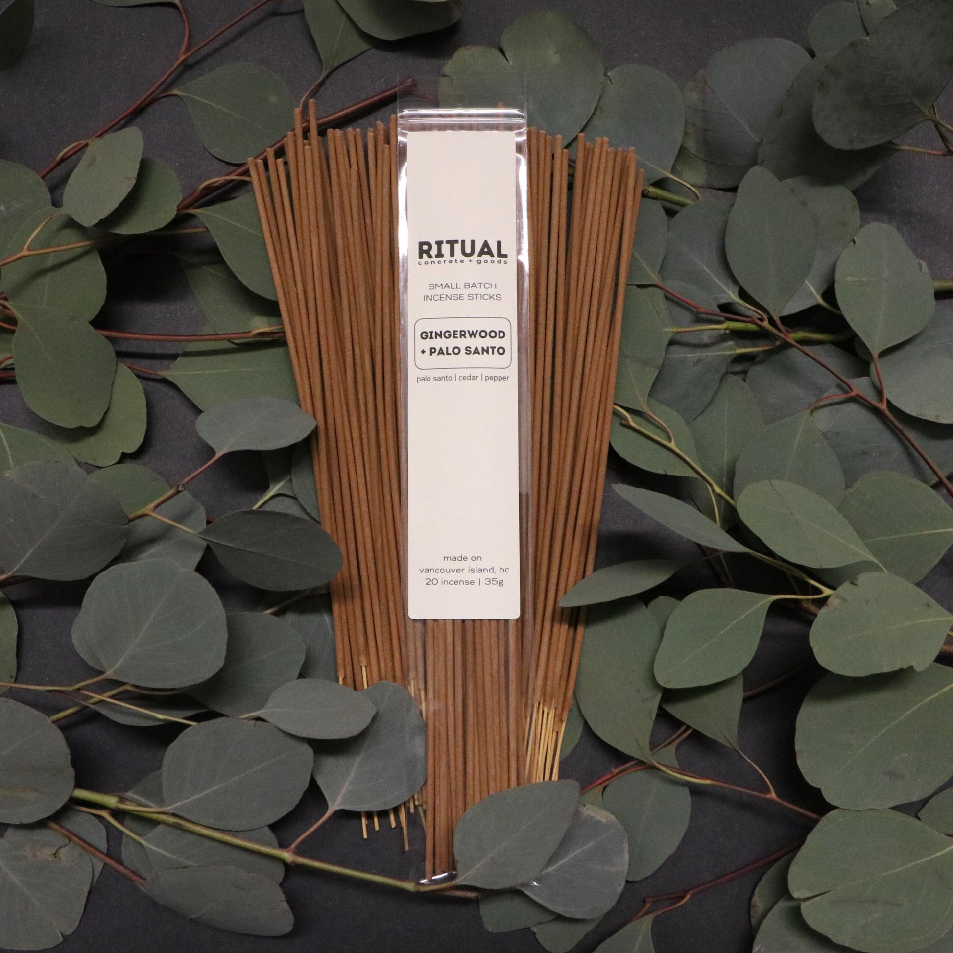 Ritual incense sticks with packaging on a dark background with green leaves