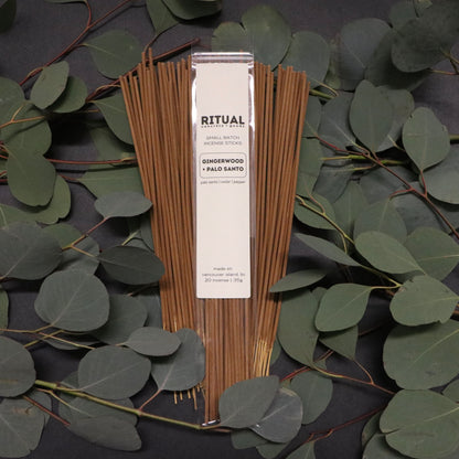 Ritual incense sticks with packaging on a dark background with green leaves